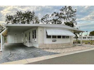 White single-wide manufactured home with carport and landscaped yard at 34212 Canal N Dr # B, Pinellas Park, FL 33781