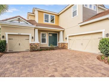 Two-story house with a teal front door and two-car garage at 3803 Bonfire Dr, Odessa, FL 33556