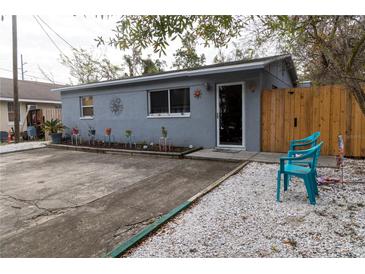 Cute bungalow with a small front yard, a concrete driveway, and a wooden fence at 438 E Martin Luther King Jr Dr, Tarpon Springs, FL 34688