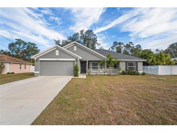 Gray house with a two-car garage and a small front porch at 6069 Newmark St, Spring Hill, FL 34606
