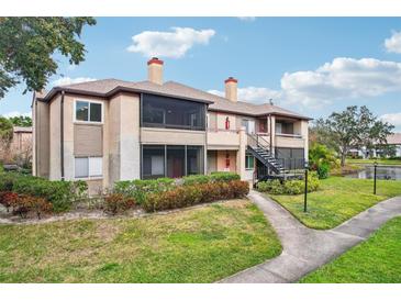 Two-story condo building with balconies, landscaping, and a walkway at 10263 Gandy N Blvd # 2206, St Petersburg, FL 33702