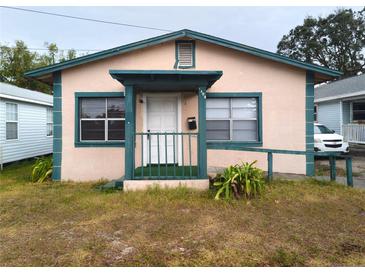 Tan house with teal accents, front porch, and small yard at 1106 Carlton St, Clearwater, FL 33755