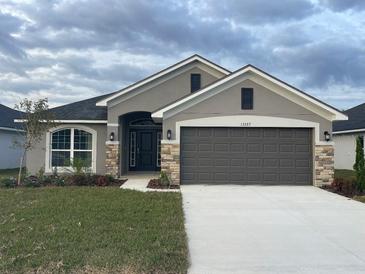 New single-story home with a two-car garage and landscaping at 13287 Ogden Glade Rd, Dade City, FL 33525