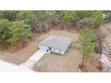 Aerial view of a single-story house with a fenced yard and driveway at 16125 Magpie Rd, Weeki Wachee, FL 34614