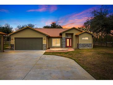 Single-story home with attached garage and attractive landscaping at 18010 Okeene Dr, Hudson, FL 34667