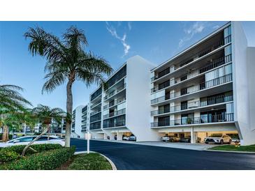 White building exterior, palm trees, and ample parking at 19111 Vista Bay Dr # 304, Indian Shores, FL 33785