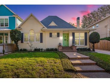 Charming bungalow with a green door, brick walkway, and manicured lawn at 2812 W Neptune St, Tampa, FL 33629