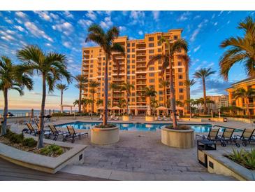 Resort-style pool with lounge chairs and a large residential building in the background at 470 Mandalay Ave # 306, Clearwater Beach, FL 33767