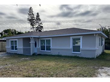 Newly constructed home with gray exterior, landscaping, and a spacious yard at 5352 Tangerine Dr, New Port Richey, FL 34652