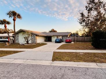 Single-story home with a large driveway and mature landscaping at 13986 Bonnie Brae Dr, Largo, FL 33774