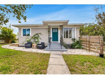 Charming bungalow with teal door, landscaping, and a walkway at 1437 Park St, Clearwater, FL 33755