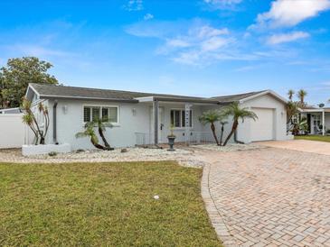 Single story home with gray exterior, brick driveway and landscaping at 3148 Domino Dr, Holiday, FL 34691