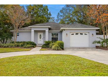 Gray house with a two-car garage and landscaped lawn at 808 W Hollywood St, Tampa, FL 33604