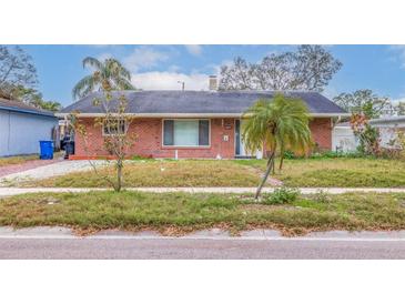 Brick home with a well-maintained lawn at 120 80Th N Ave, St Petersburg, FL 33702