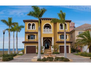 Luxury waterfront home with palm trees, fountain, and attached garage at 6408 Bright Bay Ct, Apollo Beach, FL 33572