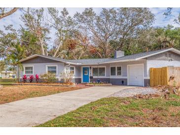 Charming ranch home with gray exterior, blue door, and landscaped yard at 7000 Dr Martin Luther King Jr S St, St Petersburg, FL 33705