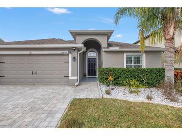 Curb appeal abounds with this charming home featuring a well-manicured lawn and paver driveway at 10405 White Peacock Pl, Riverview, FL 33578