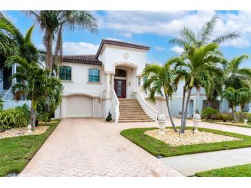 Stunning two-story home with a grand entrance and meticulously landscaped grounds at 105 Wimbledon Ct, Redington Shores, FL 33708