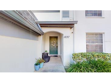 Inviting front entrance with a teal door, stone pathway, and lush landscaping at 1237 N Mcmullen Booth Rd # 1237, Clearwater, FL 33759