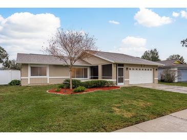 Single-story home with landscaped yard and attached garage at 14315 Arbor Hills Rd, Tampa, FL 33625