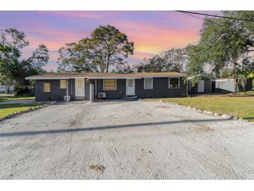 Gray duplex with spacious yard, ample parking, and detached shed at 281 Grove Rd, Venice, FL 34293