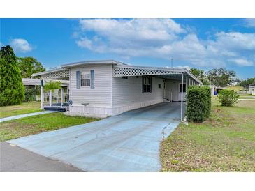 White single-wide manufactured home with carport and covered porch at 37350 Tropical Dr, Zephyrhills, FL 33541