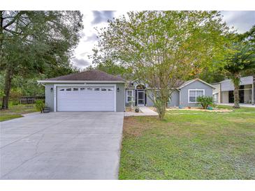 House exterior boasts a white garage door and well-manicured lawn at 38902 Inez Ave, Zephyrhills, FL 33542