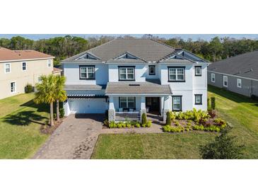 Two-story home with gray roof, white siding, and landscaping at 3898 Barbour Trail, Odessa, FL 33556