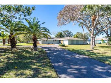 Ranch-style home with palm trees and a long driveway at 5105 W Country Club Dr, Sarasota, FL 34243