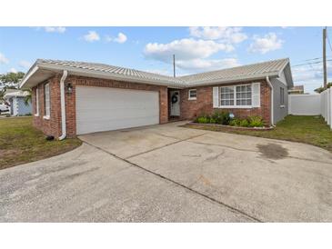 Brick ranch home with attached garage and landscaped front yard at 6950 113Th St, Seminole, FL 33772