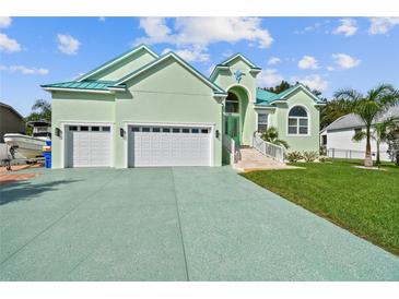 Beautiful light green house with a three-car garage and lush lawn at 711 Eagle Ln, Apollo Beach, FL 33572