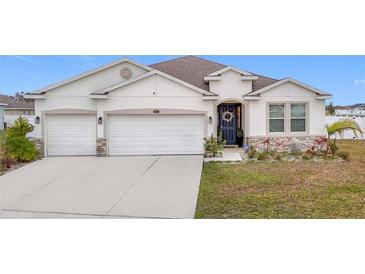 Two-story house with a two-car garage and landscaped lawn at 7395 Steer Blade Dr, Zephyrhills, FL 33541