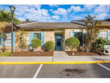 Inviting condo exterior with teal door and landscaping at 8615 Carroll Oaks Dr, Tampa, FL 33614