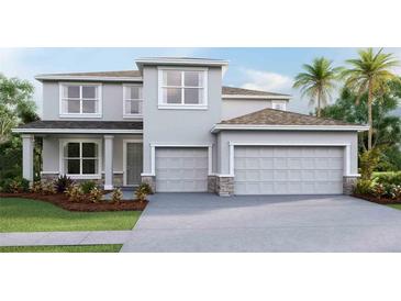 Two-story house with gray siding, stone accents, and a two-car garage at 10521 Bridgegate Heights Loop, San Antonio, FL 33576