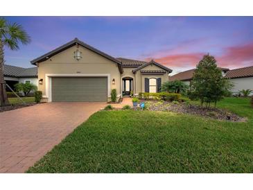 Single-story home with a two-car garage and landscaped front yard at 10804 Wicker Park Pl, Palmetto, FL 34221