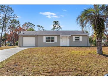 Updated single-story house with a gray exterior, white shutters, and a well-maintained lawn at 13178 Thrush St, Spring Hill, FL 34609