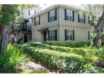 Tan two-story house with black shutters, lush landscaping, and a courtyard at 1008 S Moody Ave # 6, Tampa, FL 33629