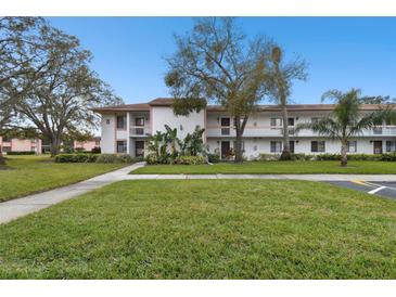 Inviting two-story condo with balconies, mature trees, and a well-maintained green lawn at 130 Lakeview Way # 130, Oldsmar, FL 34677