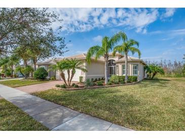 Charming single-story home featuring tropical landscaping, a tile roof and an attached two-car garage at 16127 Cape Coral Dr, Wimauma, FL 33598