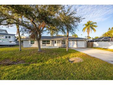 Ranch-style home with mature landscaping, attached garage, and spacious yard at 608 Florida Blvd, Crystal Beach, FL 34681