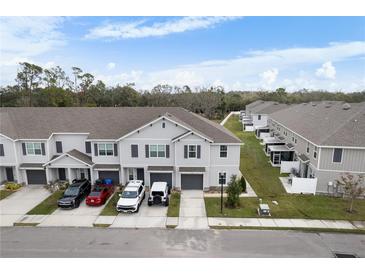 Aerial view of townhouses with parking and a pond at 9642 Sweetwell Pl, Riverview, FL 33569