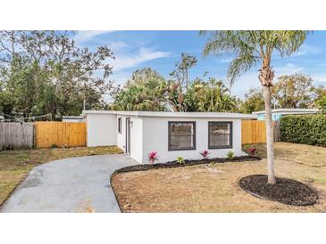 Newly renovated home with a modern exterior, landscaped yard, and driveway at 11882 104Th St, Largo, FL 33773