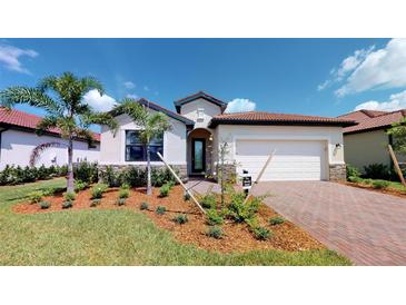 Two-story home with brick driveway and landscaped lawn at 14952 Serene Shores Loop, Lakewood Ranch, FL 34211