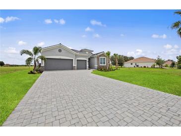 Two-story house with gray siding, three-car garage, and paver driveway at 15143 Sea Salt Way, Bradenton, FL 34211