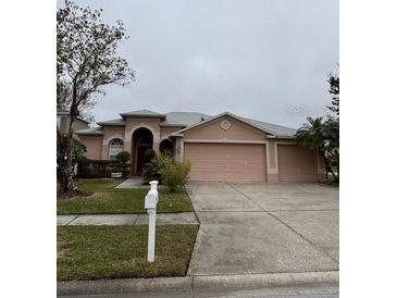 One-story house with two-car garage, landscaped yard, and a neutral color palette at 16201 Muirfield Dr, Odessa, FL 33556