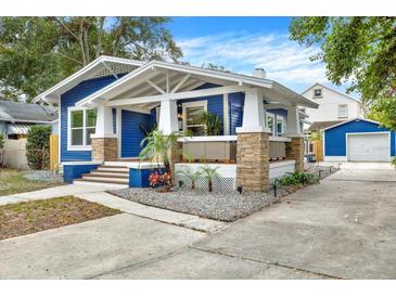 Charming blue house with white trim, stone accents, and a landscaped yard at 207 E Selma Ave, Tampa, FL 33603