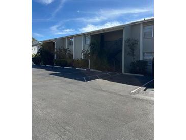 Exterior view of condo building with parking lot and landscaping at 306 S Habana Ave # 7, Tampa, FL 33609