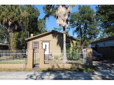 Tan house with white fence and palm tree in front yard at 3504 E 22Nd Ave, Tampa, FL 33605