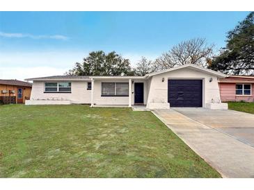 Updated ranch home with fresh landscaping and a modern garage door at 4549 Madison St, New Port Richey, FL 34652