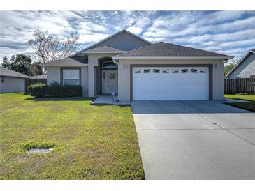 One-story house with attached garage and well-manicured lawn at 6932 Oakcrest Way, Zephyrhills, FL 33542